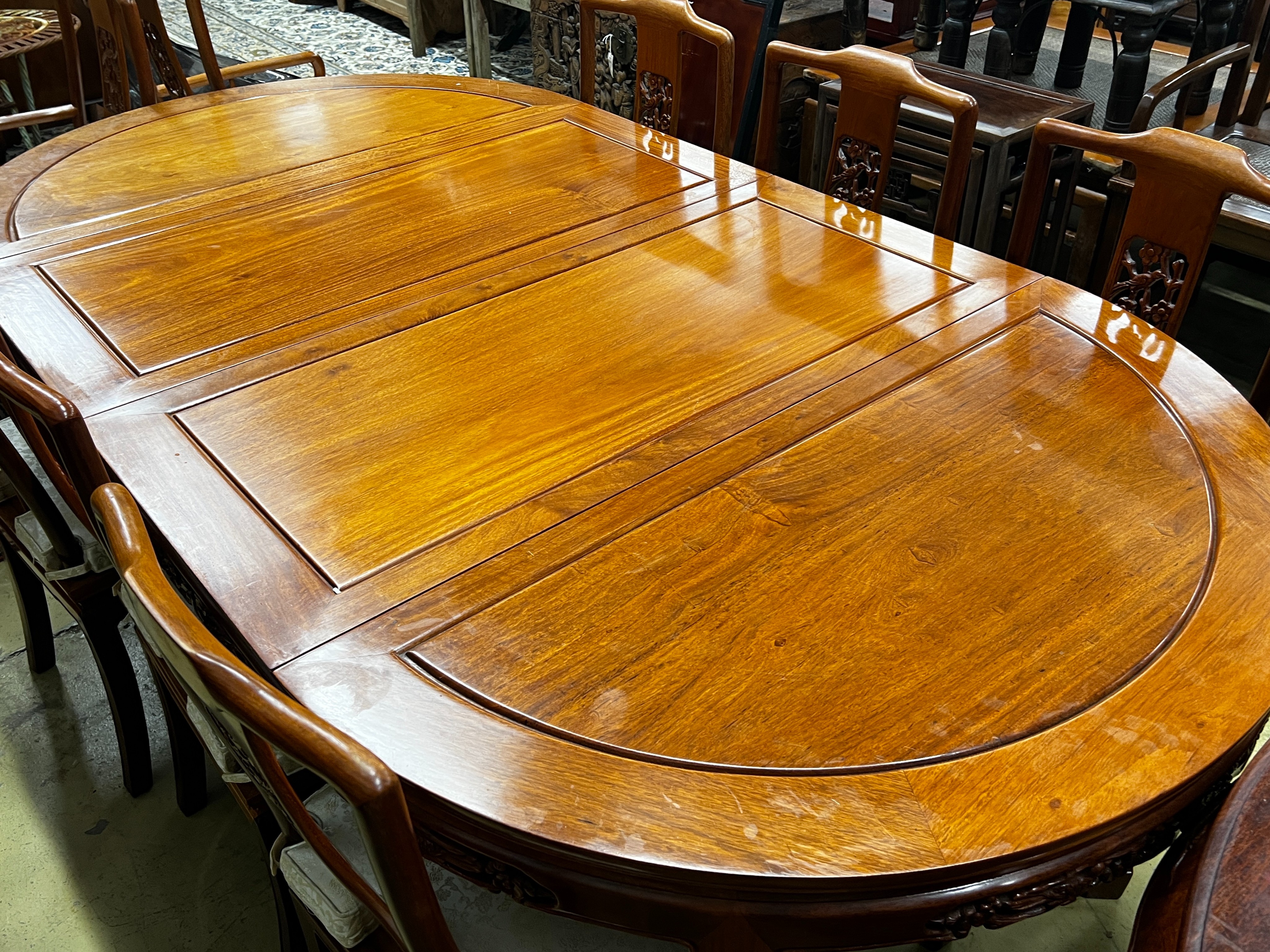 A Chinese hardwood extending dining table, length 214cm, width 111cm, height 77cm extended, two spare leaves together with eight chairs (2 with arms)